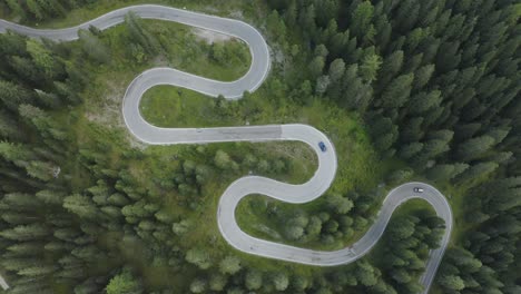 Town-down-aerial-tracking-view-of-sports-car-driving-over-winding-German-roads