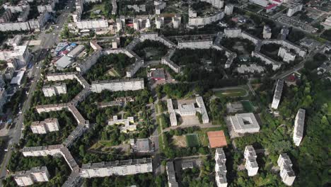 Aerial-View-of-Geometrically-Shaped-Buildings-in-a-City-Surrounded-by-Trees