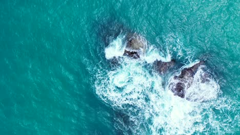 Foamy-waves-crashing-on-the-boulders-in-the-aquamarine-sea