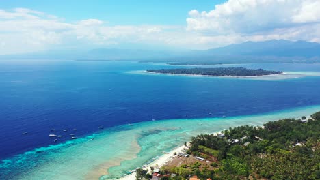 Peaceful-seaside-with-tropical-islands-surrounded-by-turquoise-lagoon-under-dusty-sky-with-clouds-hanging-over-blue-sea,-Bali