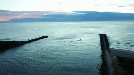 Lone-boat-ventures-out-at-sunrise,-Gold-Coast-Seaway,-blue-hour,-Dawn