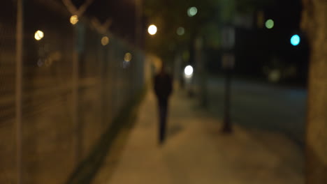 African-American-Teen-Walks-Into-Focus-on-Street-at-Night-and-Smiles