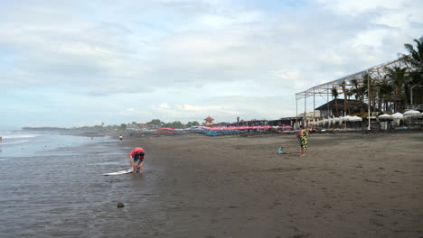 Mann-Macht-Sich-Bereit,-Im-Meer-Vor-Der-Wunderschönen-Küste-Balis-Zu-Surfen