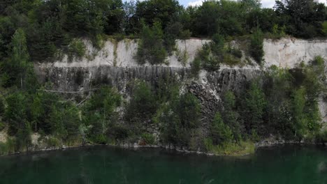 Aerial-View-of-a-Quarry-Tracking-Backward-Revealing-Lake-with-Still-Water