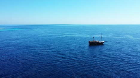 Un-Barco-Aislado-En-La-Superficie-De-La-Vasta-Extensión-Del-Vibrante-Océano-Azul-Con-Hermosos-Cielos-Despejados