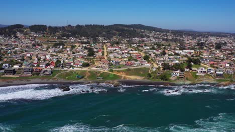 aerial:-view-of-infiernillo-beach-in-the-city-of-pichilemu-also-overlooking-the-town-with-black-sand-beach-and-houses-on-the-beach-drone-shot-chile-pichilemu-punta-de-lobos-en-colchagua-cardenal-caro