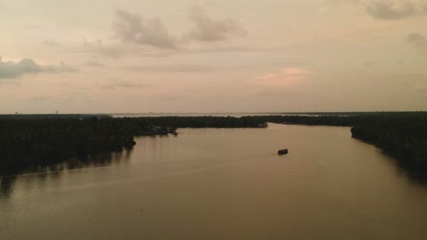 Beautiful-aerial-shot-of-a-backwater-Vembanadu-Lake,water-lines,twilight-sunset,coconut-trees-,water-transportation,clouds,reflation,House-boat-cruise