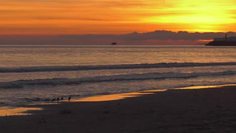 Beach-sunrise-dawn-with-fishing-boat-on-horizon