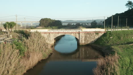 Flug-Zur-Alten-Steinbogenbrücke-über-Den-Ruhigen-See-Des-Alcobaca-Flusses-In-Der-Nähe-Von-Nazare,-Portugal