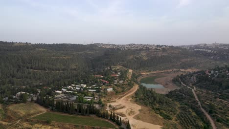 Aerial-shot-over-small-settlement-inside-a-forested-area-in-the-Jerusalem-mountains,-drone-shot