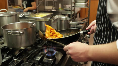Restaurant-Chef-Tosses-Penne-Pasta-Being-Cooked-In-The-Kitchen---close-up,-slow-motion