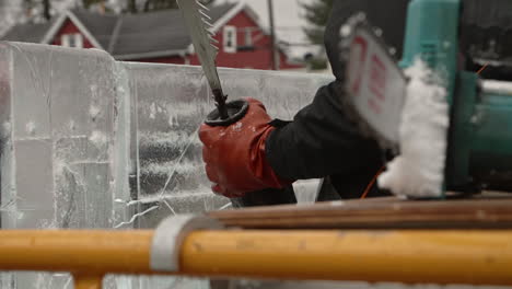 Rack-focus-from-electric-chainsaw-blade-to-ice-sculptor-with-reciprocating-saw,-Slow-Motion