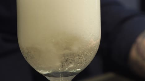 Foamy-pour-of-sparkly-wine-into-a-narrow-glass---Close-up-shot