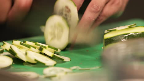 Skilled-Chef-Fastly-Chopping-Cucumber-Using-A-Sharp-Knife-In-The-Kitchen-Of-A-Restaurant