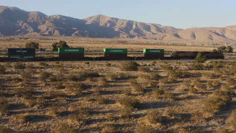 Lokomotive-Eisenbahn-Transportiert-Fracht-In-Der-Kalifornischen-Wüste,-Luftaufnahme