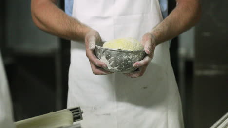 Baker-Forming-Dough-In-A-Small-Mixing-Bowl---Slow-Motion