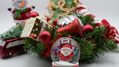 Santa-Claus-En-Un-Globo-De-Nieve,-Adornos-Navideños-Alrededor-Del-árbol-De-Navidad