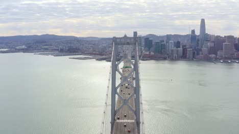 Aerial:-drivers-crossing-the-bridge-towards-the-city,-drone-view