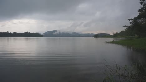 Calm-misty-lake-with-mountains-in-the-distance