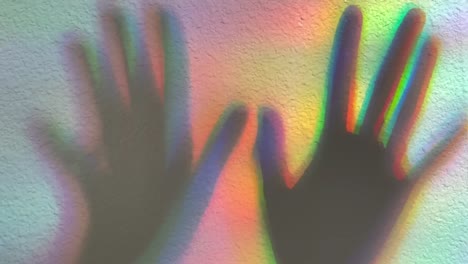 Shadow-of-two-hands-casted-onto-a-rainbow-colored-background