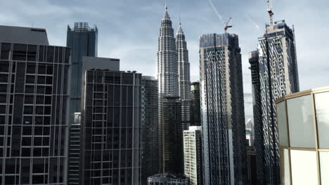 Aerial-Shot-Of-City-Buildings-And-Petronas-Twin-Towers-In-Kuala-Lumpur,-Modern-Architecture