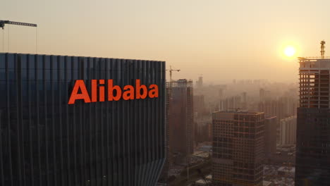 Close-fly-by-near-Alibaba-Group-office-building-with-reveal-of-Canton-Tower-and-downtown-CBD-area-in-background-at-beautiful-golden-sunset