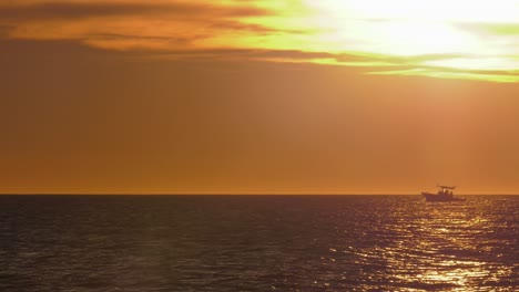 Motorboot-Am-Horizont-Mit-Goldenem-Sonnenlicht-Auf-Dem-Wasser,-Mittelmeerküste,-Spanien