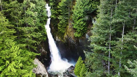 Slow-motion-pullback-aerial-shot-of-Silver-Falls-waterfall-in-British-Columbia,-Canada