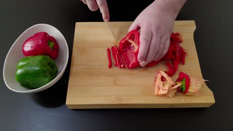 Hand-of-chef-finely-slices-red-pepper