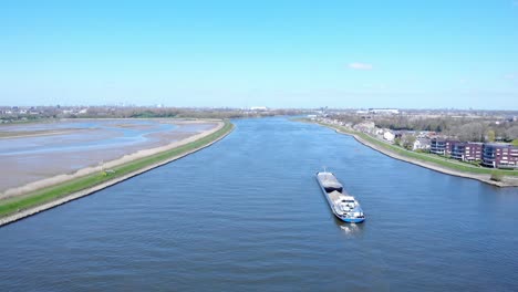 Aerial-View-Of-Barge-At-Noord-River-Under-Bright-Blue-Sky-At-Daytime-Near-Hendrik-Ido-Ambacht,-Netherlands