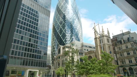 Lockdown-in-London,-cinematic-reveal-of-The-Gherkin-with-empty-courtyard-and-St-Andrew-Undershaft-Church,-during-the-Coronavirus-pandemic-2020