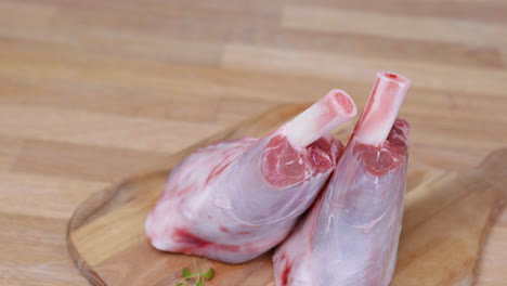 Two-Lamb-Shanks-on-Wooden-Cutting-Board
