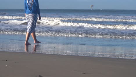 Woman-walks-on-the-beach-and-plays-in-the-waves