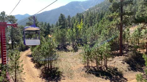 Riding-aerial-chairlift-in-Colorado-amusement-park,-enjoying-mountain-scenery