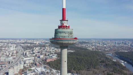 AERIAL:-Flying-Away-with-Drone-from-Vilnius-TV-Tower-with-Blue-Sky-Behind-It