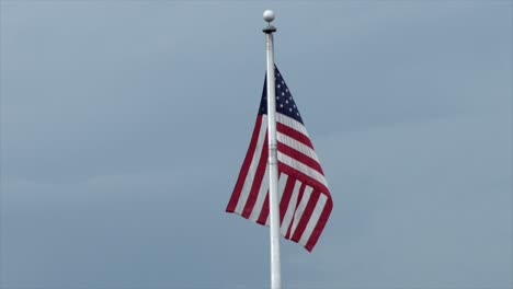 Amerikanische-Flagge-Am-Fahnenmast,-Die-Im-Wind-Vor-Blauem-Himmel-Weht---Zeitlupe