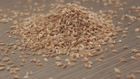 Wheat-spelt-grain-rotating-on-wooden-background