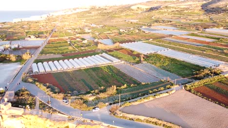 Agricultural-land-of-Malta-with-many-greenhouses,-aerial-orbit-view