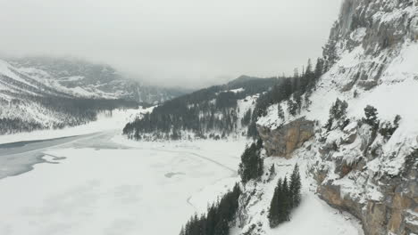 Aerial-of-snow-covered-mountain-wall-overlooking-valley