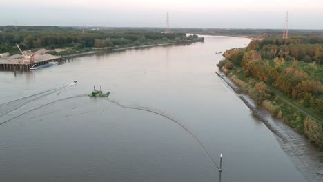 Speedboat-getting-away-on-river-Schelde,-aerial-drone-view
