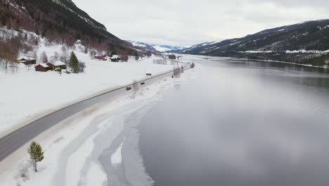 Cars-Driving-Through-Road-In-The-side-Of-Mountains-In-Norway---aerial-shot