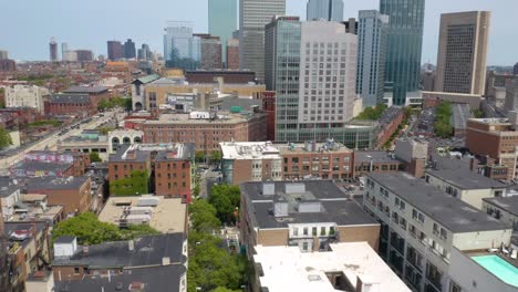 Drone-Flying-Away-from-Downtown-Boston-Reveals-Green-Trees-in-Park,-River