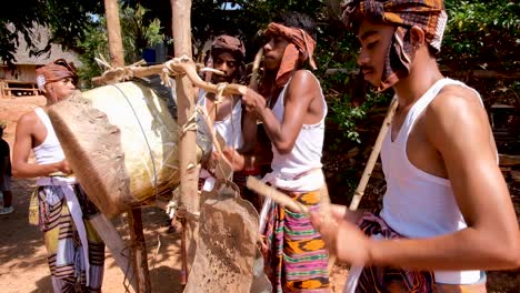 Eine-Gruppe-Kleiner-Jungen,-Die-Eine-Selbstgemachte-Trommel-Spielen,-Um-Besucher-In-Ihrer-Abgelegenen-Dorfgemeinschaft-In-Timor-Leste,-Südostasien,-Willkommen-Zu-Heißen