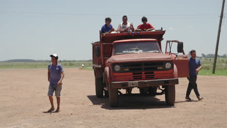 Personas-En-El-Cuerpo-Del-Camión,-Conductor-Y-Pasajero-Saliendo-Del-Camión