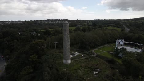 Drone-shot-of-a-round-tower-with-countryside-in-the-background