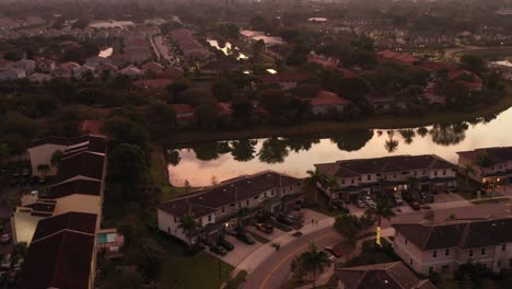 An-aerial-view-of-a-lake-in-a-residential-area-during-a-cloudy-sunrise-in-Florida