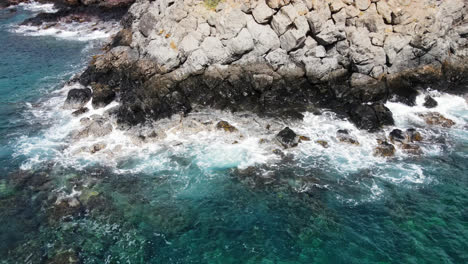Waves-crashing-over-rocks-along-the-shoreline-in-Maui,-Hawaii