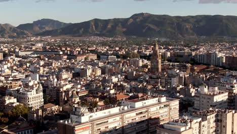 Aerial-shot-flying-over-Murcia-city-with-a-mountain-backdrop-in-Spain