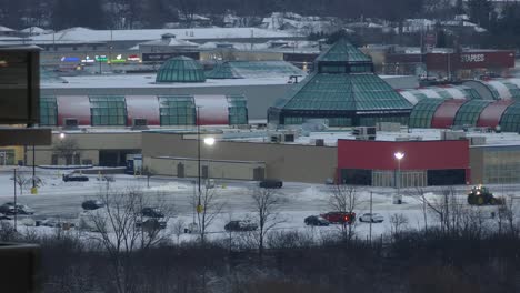 A-timelapse-of-the-parking-lot-of-Woodbine-Shopping-Centre,-as-a-worker-in-a-tractor-clears-snow-and-ice-after-a-recent-heavy-snowstorm-on-a-cold-winter’s-day,-Etobicoke,-Canada