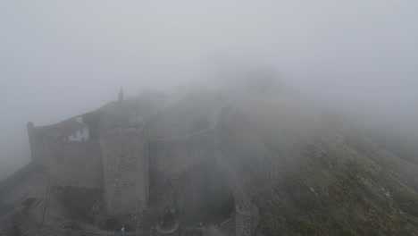 Una-Espesa-Niebla-Sobre-Un-Castillo-Medieval-Es-Vista-Por-Un-Dron-Que-Vuela